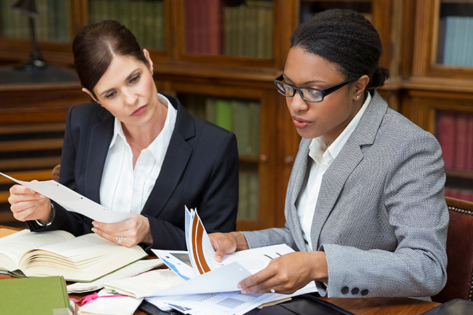 Two female lawyers in an office doing legal research