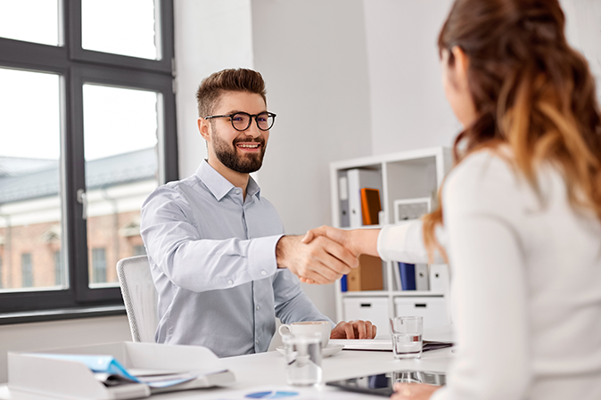 Young man shaking the hand of a new client in the office
