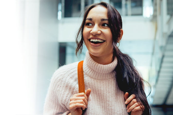 Young woman smiling with backpack in college