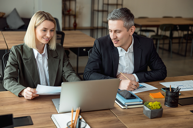 Two lawyers working together on a laptop in the office
