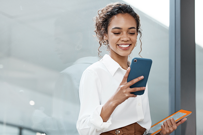 Young woman on her mobile phone while holding tablet