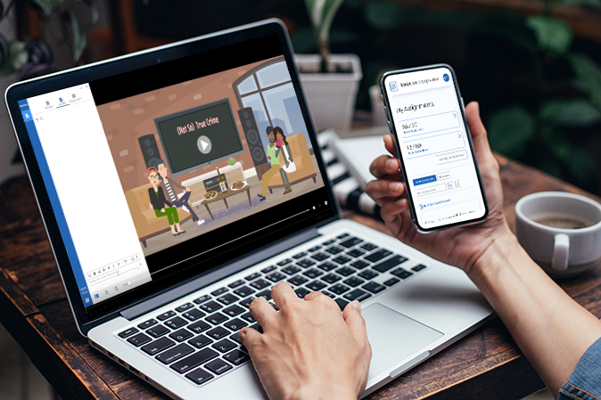 Person holding mobile phone while typing on laptop