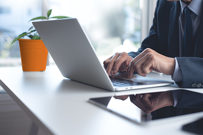 Businessman working on laptop computer, surfing the internet, searching the information with digital tablet on white office table. Man project manager at work, business and technology concept