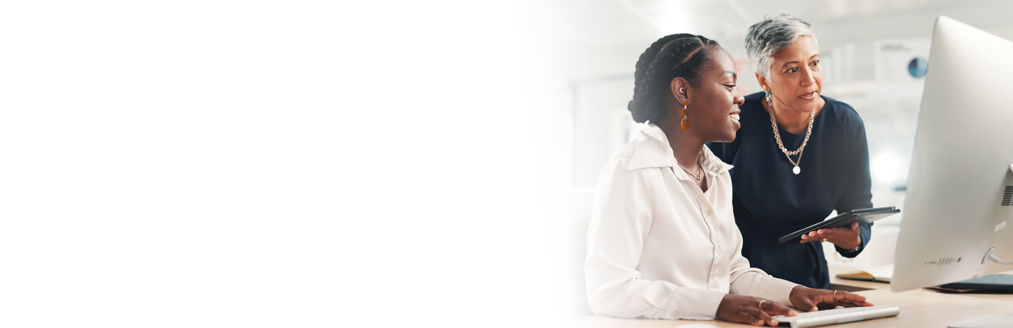 Professor helping a college student on a computer in class