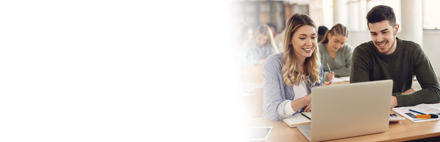 Female student working on laptop with male colleague
