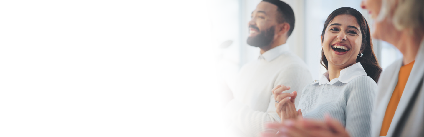 Young woman smiling and clapping with another event attendee