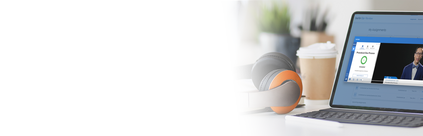 Pair of headphones next to a laptop with a Bar Review lecture on the screen