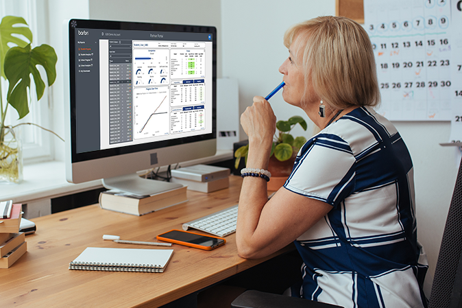 Female professor looking at the Partner Portal on her computer screen in her office