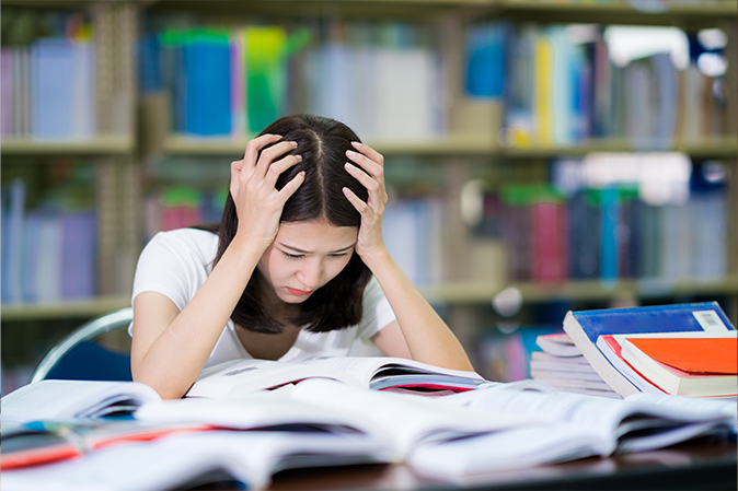 Young woman stressed out in front of her latop studying