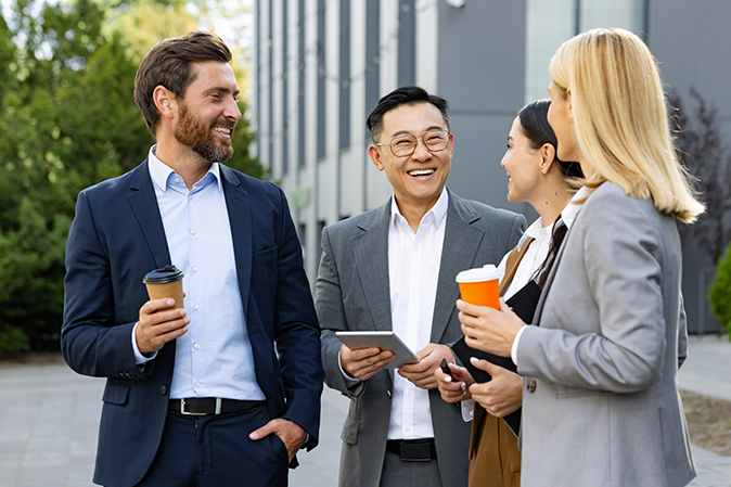 Group of professionals networking outside and office building