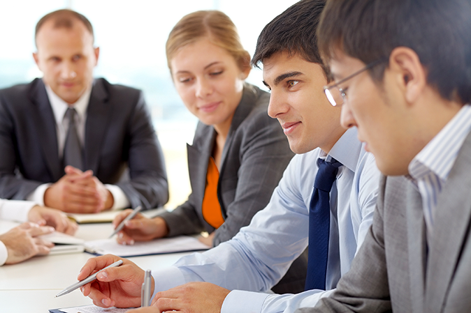 Young man presenting at a meeting with his colleagues